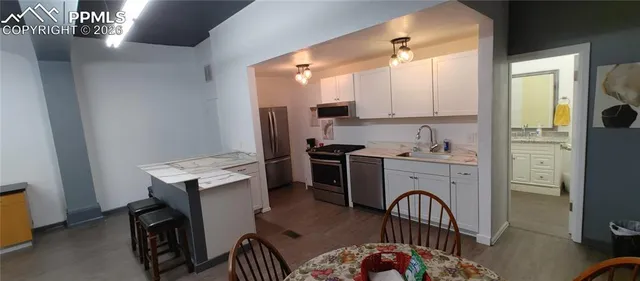 a kitchen with a refrigerator and a stove top oven