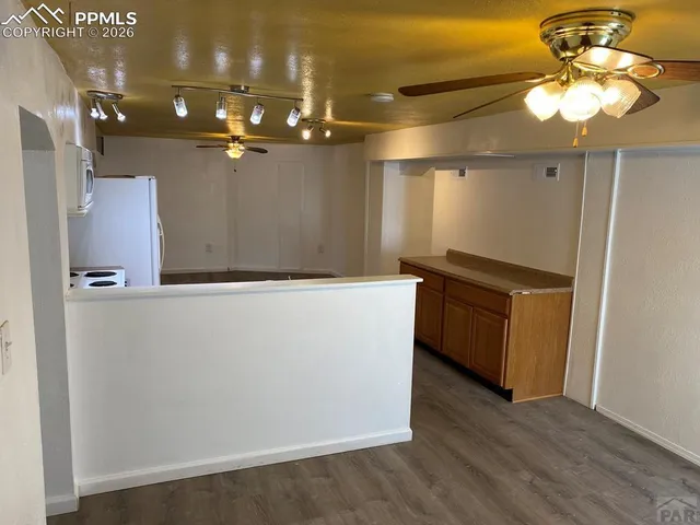 a kitchen with stainless steel appliances a refrigerator and a wooden floor