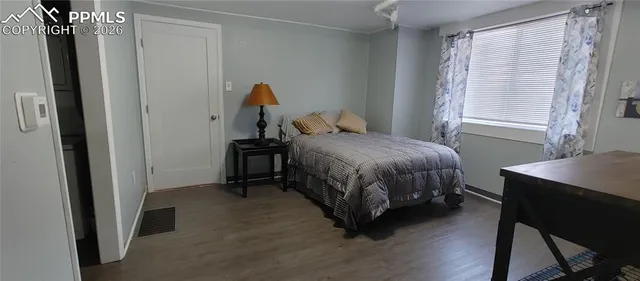 a bedroom with a bed table and a window