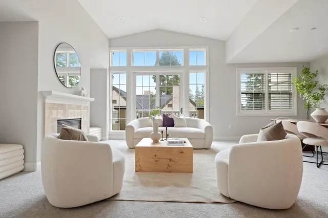 a living room with fireplace furniture and a large window