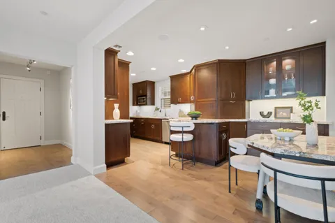 a open kitchen with a table chairs refrigerator and cabinets