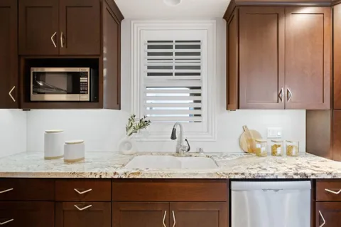 a kitchen with granite countertop stainless steel appliances sink and cabinets
