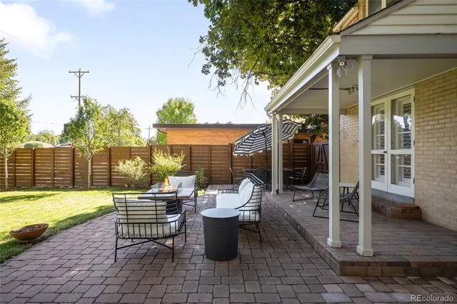a view of a patio with a dining table and chairs with wooden floor
