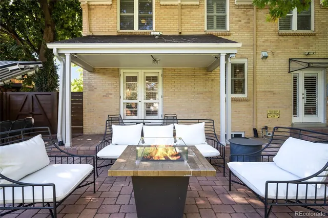 a view of a patio with couches table and chairs and potted plants