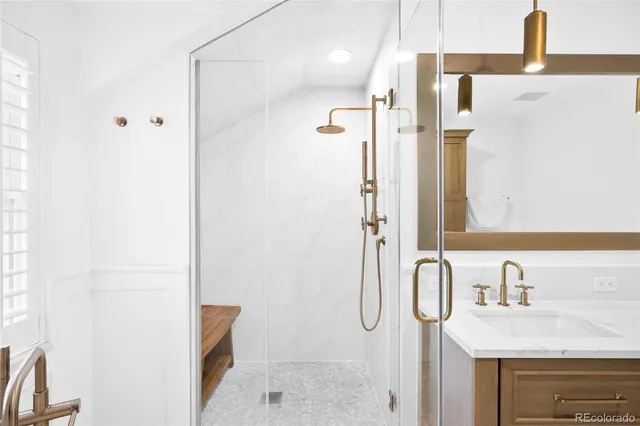 a bathroom with a granite countertop sink a mirror and shower