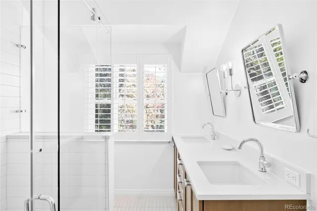 a bathroom with a sink a vanity and a shower