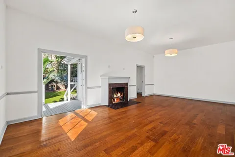 a view of an empty room with a fireplace and a window