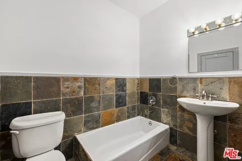 a bathroom with a sink a toilet and mirror