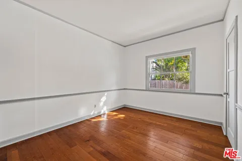 a view of a room with wooden floor and window