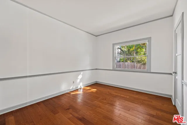 a view of a room with wooden floor and window