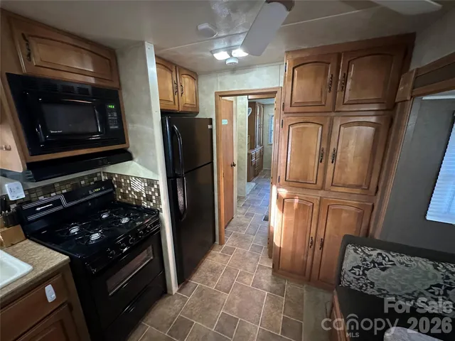 a kitchen with granite countertop a refrigerator stove and microwave