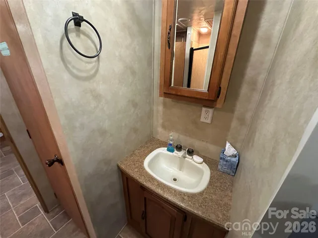 a bathroom with a sink vanity and a mirror