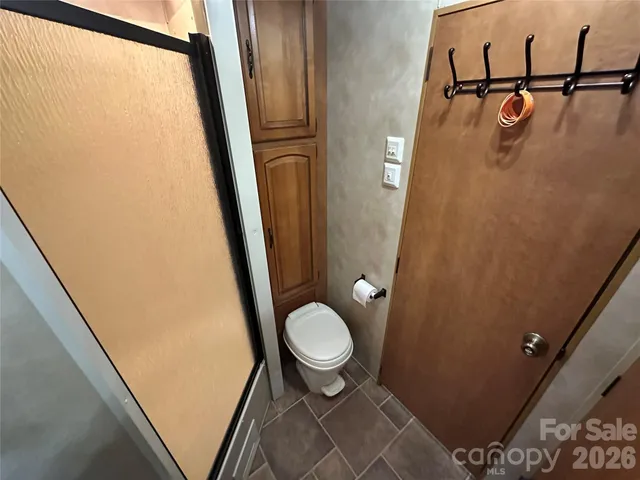 a bathroom with a granite countertop toilet and a sink