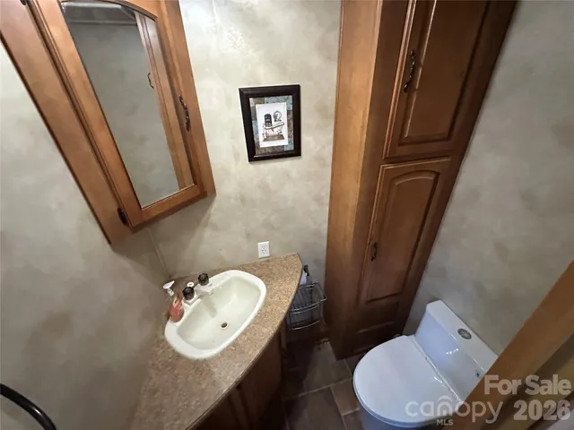 a bathroom with a toilet a sink and mirror