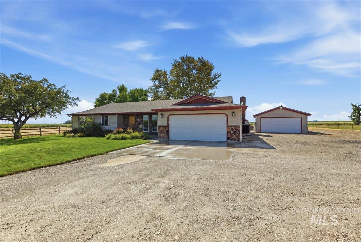 26201 Hop Road Caldwell, ID 83607 - Photo 2 of 45 Stone and siding exterior with an attached two-car garage, separate detached garage, and a gravel driveway