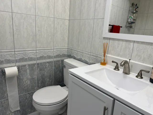 a bathroom with a toilet sink and mirror