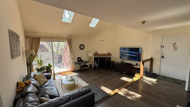 a living room with furniture and a flat screen tv with wooden floor