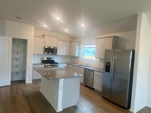 a kitchen with stainless steel appliances granite countertop a sink stove and refrigerator