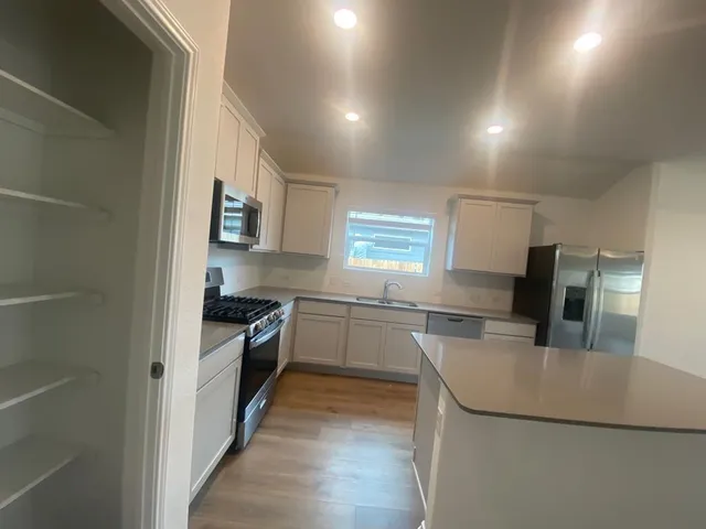 a kitchen with granite countertop a sink stove and refrigerator