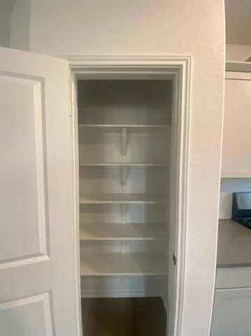 a view of walk in closet with empty racks