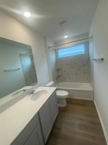 a bathroom with a granite countertop sink a toilet and shower