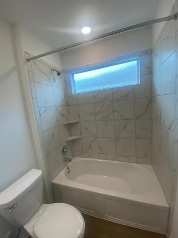 a bathroom with a toilet bathtub and shower
