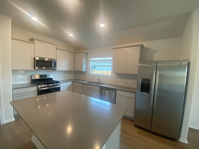 a kitchen with stainless steel appliances a refrigerator a sink a stove a microwave a counter space and cabinets