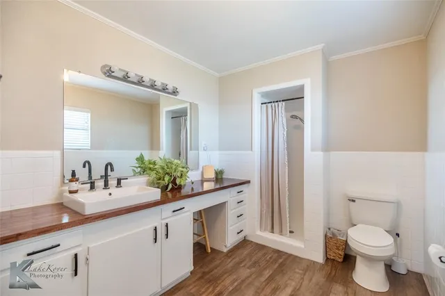 a spacious en suite bathroom with a double vanity sink and mirror