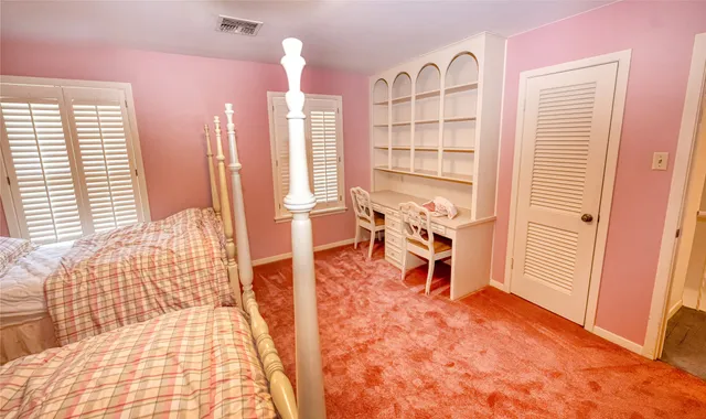 a bedroom with furniture and a large window