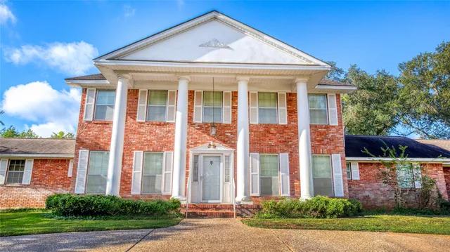 front view of a brick house with a yard