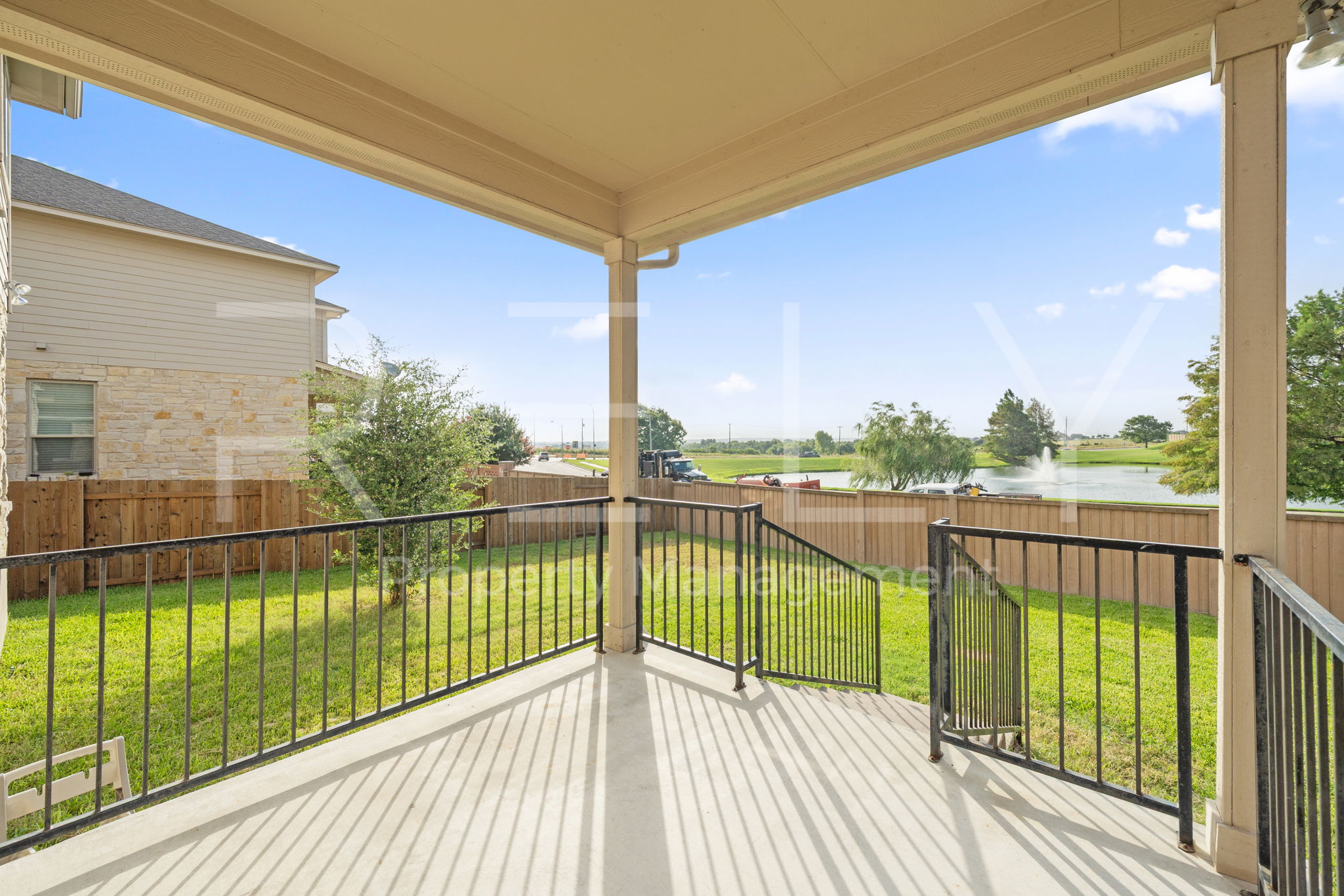 1405 Sunny Meadows Loop Georgetown, TX 78626 - Photo 34 of 40 Enjoy tranquil water views and expansive green space from this covered outdoor patio, perfect for relaxing.