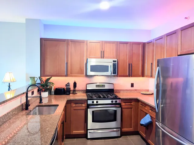 a kitchen with stainless steel appliances granite countertop a stove a sink and a refrigerator