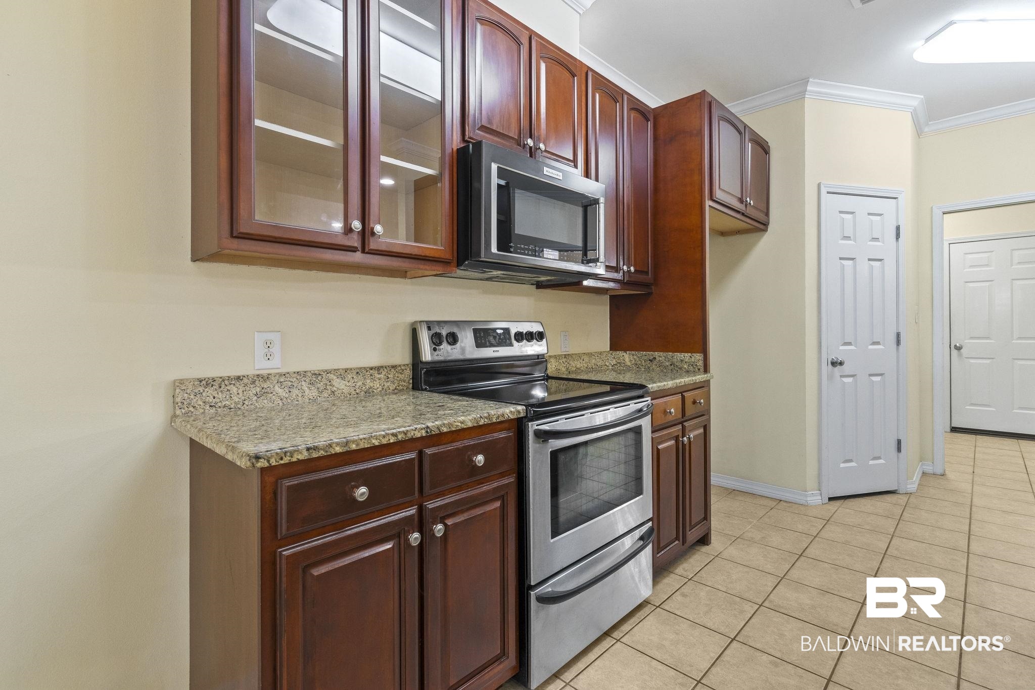 166 Club Drive Fairhope, AL 36532 - Photo 13 of 41 Kitchen featuring stone countertops, stainless steel appliances, ornamental molding, and light tile patterned flooring