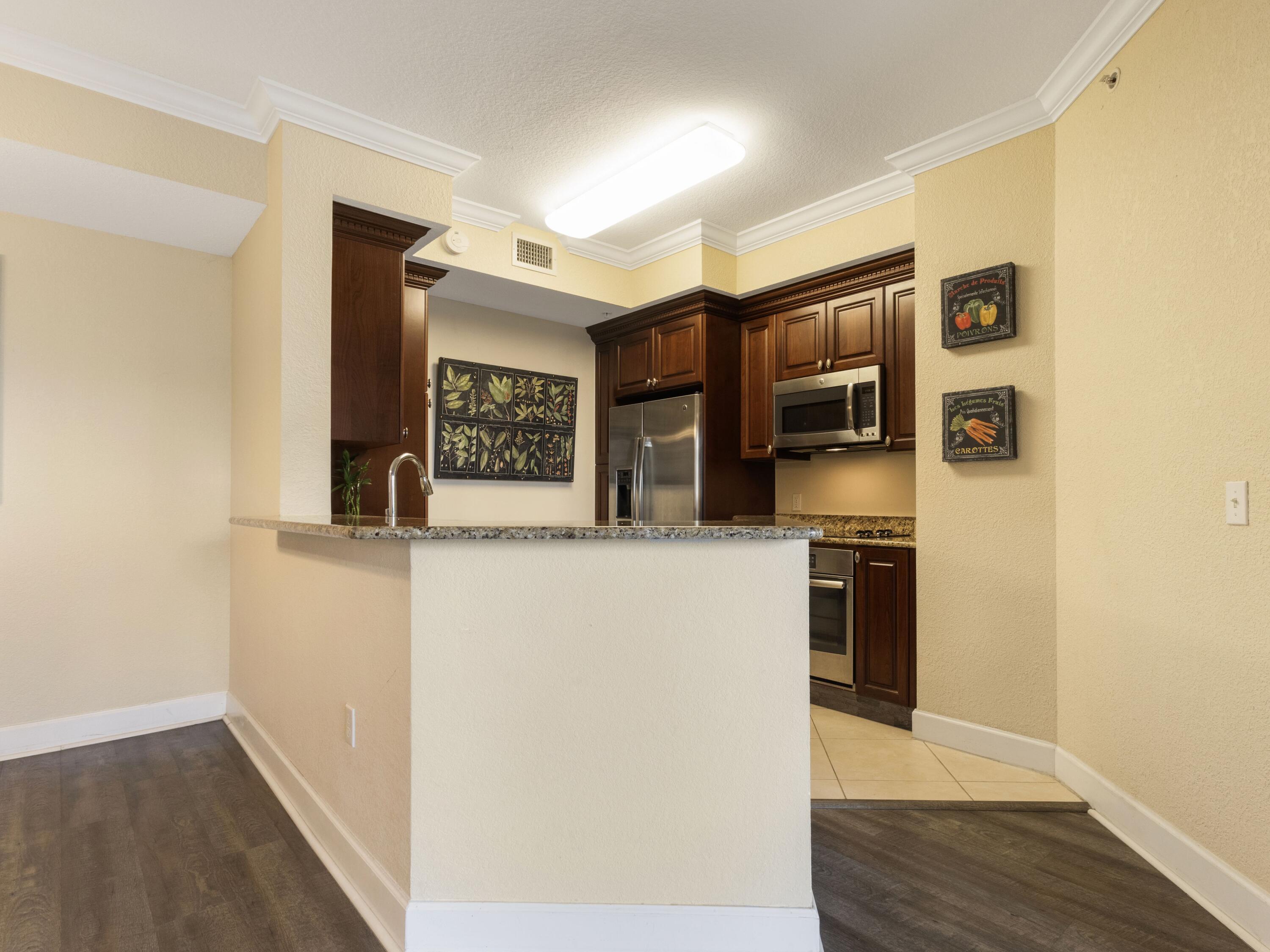 1690 Renaissance Commons Boulevard, Unit 1412 Boynton Beach, FL 33426 - Photo 3 of 49 a view of a refrigerator in kitchen and wooden floor