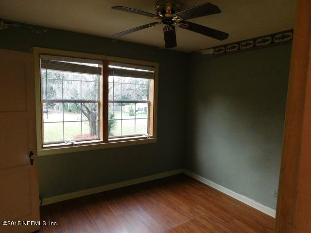 9770 Lily Road Jacksonville, FL 32246 - Photo 32 of 53 a view of an empty room with wooden floor and a window