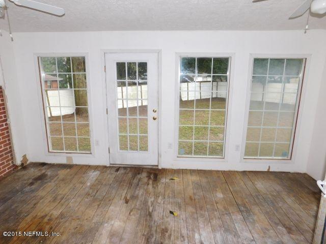 9770 Lily Road Jacksonville, FL 32246 - Photo 47 of 53 an empty room with wooden floor and windows