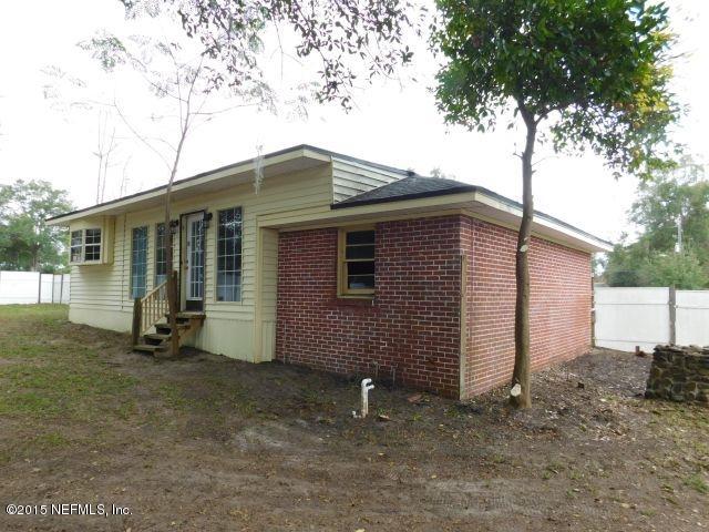 9770 Lily Road Jacksonville, FL 32246 - Photo 8 of 53 a backyard of a house with large trees and barbeque oven