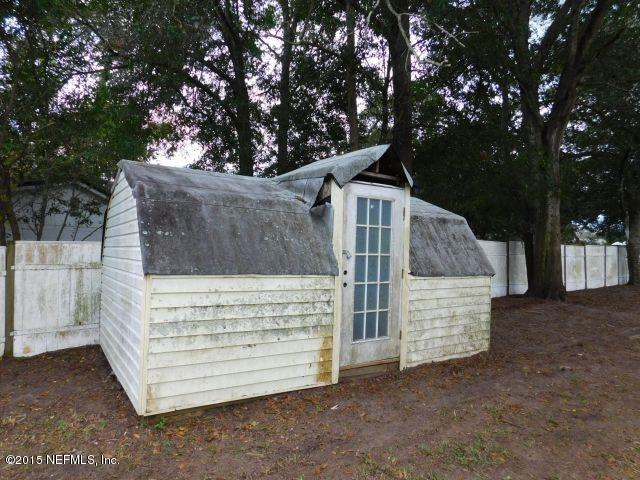 9770 Lily Road Jacksonville, FL 32246 - Photo 10 of 53 a view of a wooden house with a large tree in front of it