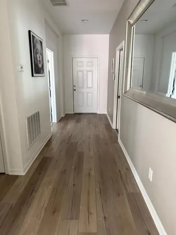 a view of a hallway with wooden floor and staircase
