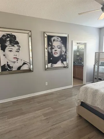 a bedroom with bed and wall painting