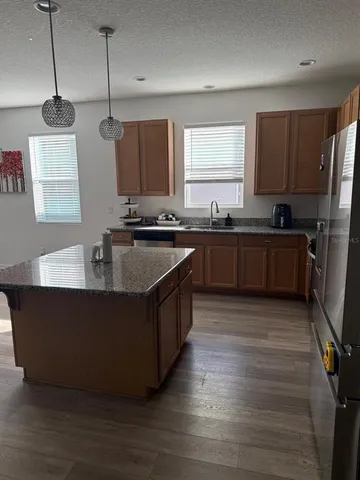 a large kitchen with stainless steel appliances granite countertop a stove a sink and a refrigerator