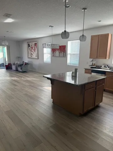 a kitchen with stainless steel appliances granite countertop a sink a stove and a wooden floor