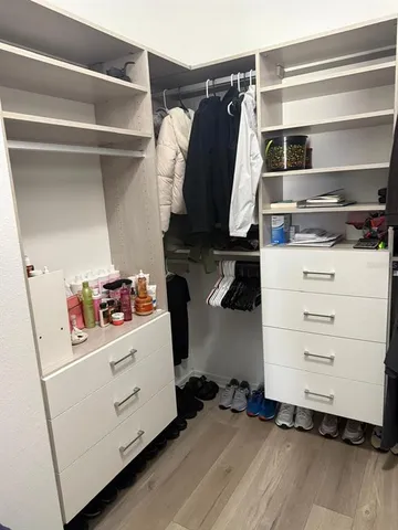 a view of walk in closet with clothes and shoes