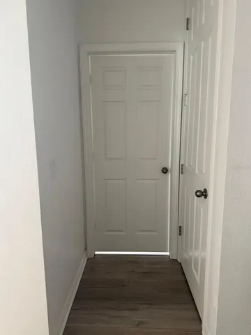 a view of a hallway with wooden floor
