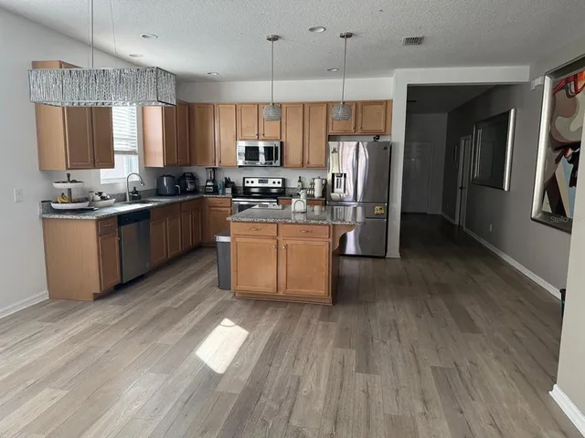 a living room with hard wood flooring furniture and a flat screen tv