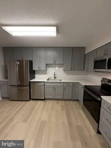 a kitchen with stainless steel appliances a refrigerator sink and cabinets