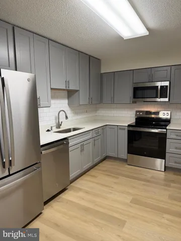 a kitchen with stainless steel appliances a refrigerator sink and microwave