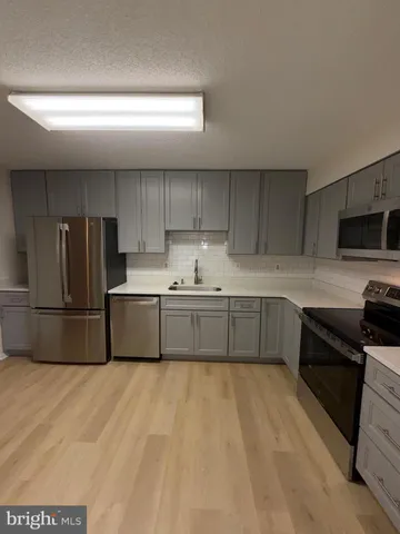 a kitchen with stainless steel appliances a refrigerator sink and cabinets