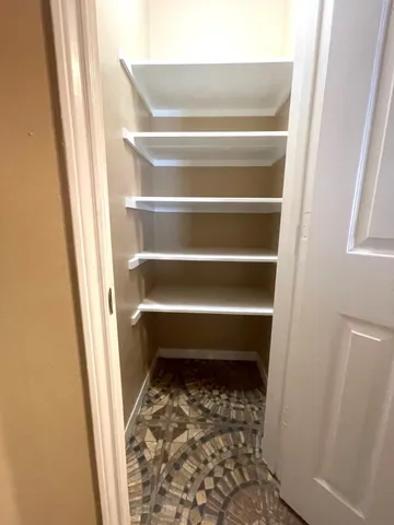 a view of a room with a chandelier fan and windows