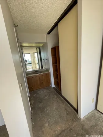 a view of a hallway with wooden floor and a kitchen